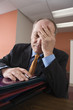 View of an exhausted businessman sitting in an office.