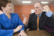 Foto: business man abusing business woman in an office. business man abusing business woman in an office.