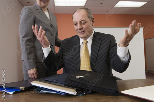 Foto: Business woman standing beside frustrated business man. Business woman standing beside frustrated business man.