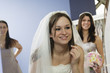Bride with her bridesmaids looking in a mirror.