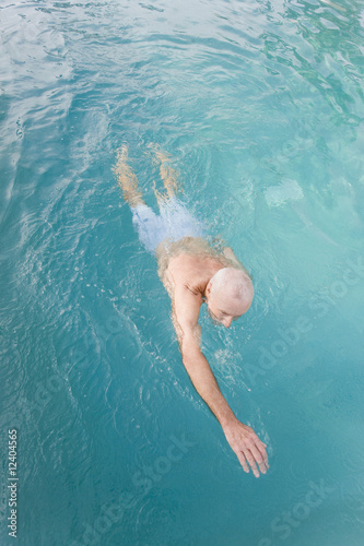 Photo: Senior man swimming in a pool Senior man swimming in a pool