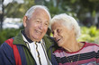 Photo: Senior couple smiling in a park. Senior couple smiling in a park.