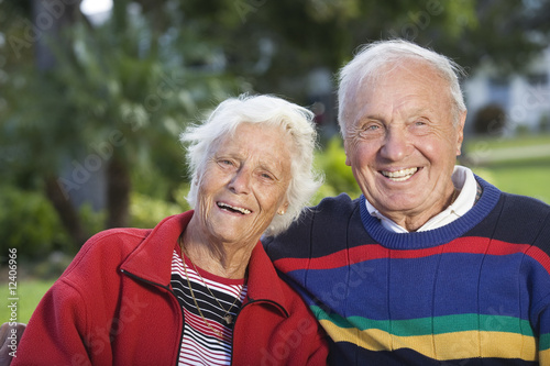 Photo: Portrait of a senior couple smiling in a park. Portrait of a senior couple smiling in a park.