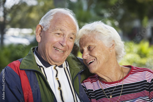 Photo: Senior couple smiling in a park. Senior couple smiling in a park.