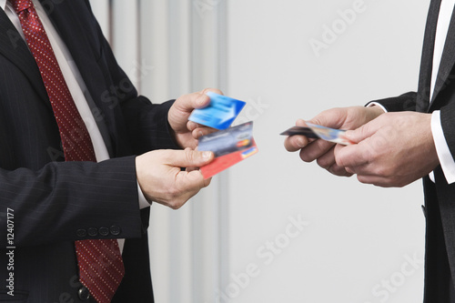 Photo: Business men holding credit cards. Business men holding credit cards.