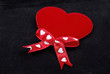 Red heart with silk ribbons macro isolated on black velvet backg Red heart with silk ribbons macro isolated on black velvet backg