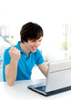 Foto: Man using laptop, clenching fist Man using laptop, clenching fist