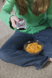 Young girl using a remote and having snacks