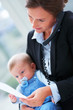 Closeup portrait of happy business woman holding a baby