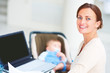Young business woman working on a laptop with her baby