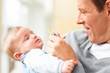 Young father carrying his baby and holding a dummy