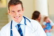 Foto: Successful doctor in uniform with a mother and her baby at the b Successful doctor in uniform with a mother and her baby at the b