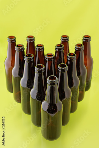 Photo: Empty beer bottles in front of a bright green background Empty beer bottles in front of a bright green background