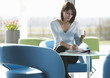 A woman sitting at a table, having a drink and writing notes