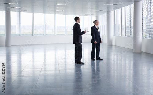 Foto: A letting agent showing a businessman around an empty office A letting agent showing a businessman around an empty office