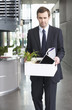 A redundant businessman taking his belongings home in a box