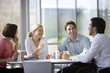 Four office colleagues eating lunch in an office canteen or cafe