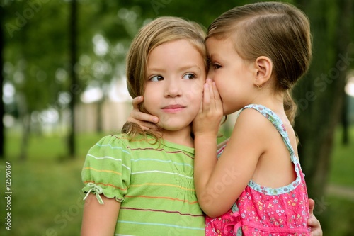 Photo: Two twin little sister girls whisper in ear Two twin little sister girls whisper in ear