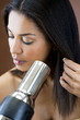 A young woman blow drying her hair