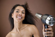 A young woman blow drying her hair