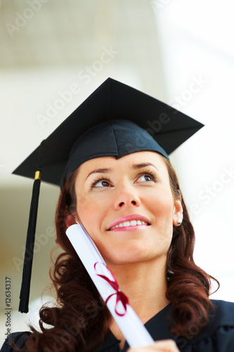 Young female graduate looking at copyspace