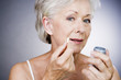 A senior woman holding a bottle of pills