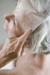 A senior woman combing her hair