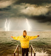 .Brave woman greeting stormy ocean