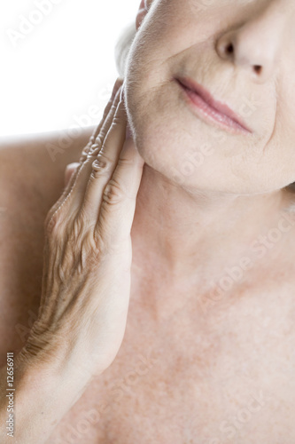 Photo: A senior woman touching her neck A senior woman touching her neck