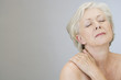 A senior woman with shoulder tension or back ache