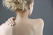 A woman with her hand on her shoulder