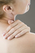 A woman with her hand on her shoulder