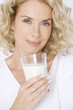 A middle-aged woman holding a glass of milk