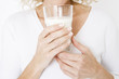 A middle-aged woman holding a glass of milk