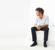 Young business man sitting on a bed looking away