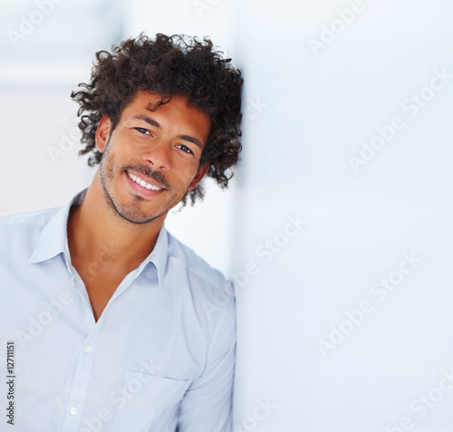 Photo: Young smiling African man isolated over a background Young smiling African man isolated over a background