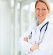 Photo: Portrait of a smiling mature female doctor with hands folded Portrait of a smiling mature female doctor with hands folded