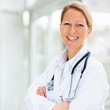 Photo: Portrait of a happy mature female doctor with hands folded Portrait of a happy mature female doctor with hands folded