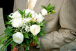 a bridegroom holding a bouquet of roses