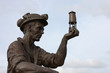 A Statue of a Coal Miner Looking at his Miner's Lamp.