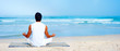 Young man meditating in front of the ocean