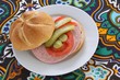 belegtes brötchen mit bierwurst, gurke und tomate