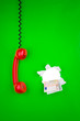 Foto: Money and red phone on green Money and red phone on green