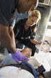 Paramedics performing CPR on patient in ambulance Paramedics performing CPR on patient in ambulance