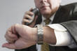 Photo: Businessman checking time and using an electronic shaver. Businessman checking time and using an electronic shaver.