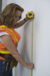 View of a woman using tape measure.