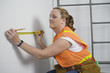View of a woman using tape measure.