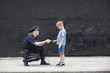 Woman police officer talking to a boy.