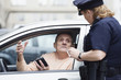 Woman police officer checking driver's license.