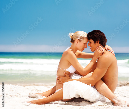 Romantic couple in love at the beach with the ocean